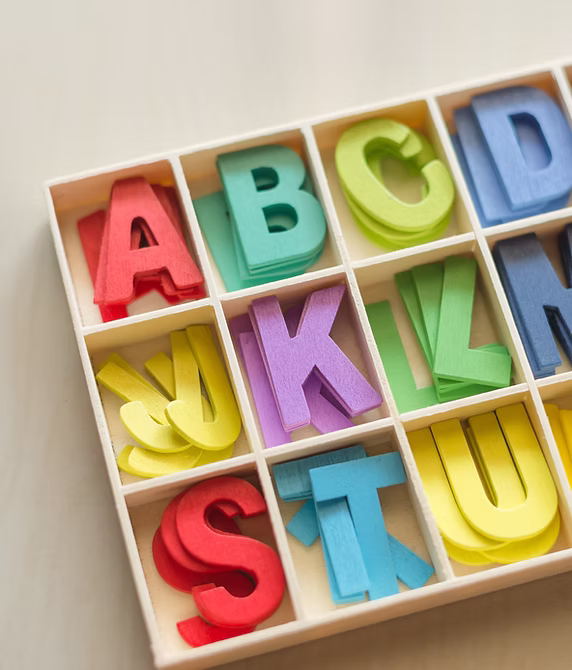 Letras del alfabeto de colores en compartimentos de madera